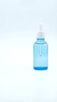 Blue glass dropper bottle with white pipette cap isolated on white background for skincare and cosmetic product packaging design.