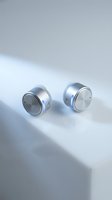 Pair of silver wireless earbuds with blue accents on white surface, showcasing modern audio technology design for product marketing and tech advertising.