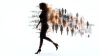 Silhouettes of walking people with motion blur effect in brown and black tones, artistic urban scene with woman in high heels in foreground against fading crowd.