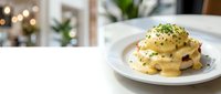 Creamy eggs Benedict with hollandaise sauce and fresh herbs on white plate, elegant brunch dish for restaurant menus and food blogs.