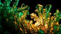 Elegant golden crystal formations with emerald green accents creating luxurious abstract patterns against dark background for premium design projects.