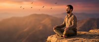 Young bearded man meditating on mountain cliff at sunset with birds flying overhead, peaceful spiritual moment in nature for wellness and mindfulness content.