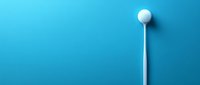 White golf ball on tee against vibrant blue background, creating minimalist sports composition with strong visual contrast and copy space.