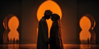 Romantic couple silhouettes embracing against warm orange sunset through ornate archway creating intimate wedding or engagement scene for love concepts.