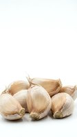 Isolated garlic cloves with papery skin on white background, ready for culinary, food photography, recipe design, and kitchen-related projects.