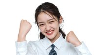 Young Asian businesswoman in white shirt and tie celebrating success with raised fists and joyful expression against white background.