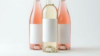 Three elegant wine bottles with blank white labels featuring rosé and white wines on clean background for branding mockup and packaging design projects.