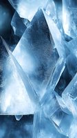 Macro shot of translucent ice crystals with sharp geometric angles and facets in cool blue tones, creating abstract natural patterns and textures for winter designs.