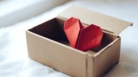 Red origami heart in kraft cardboard box on white background for Valentine's Day gifts, romantic packaging, love symbols and handmade paper crafts.