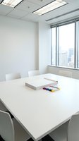 Modern corporate conference room with white table, chairs and city skyline view through large windows for business meetings and presentations.
