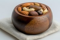 Mixed nuts and dried fruits in wooden bowl on linen napkin for healthy snacking and cooking ingredients.