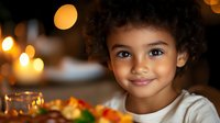 Young mixed-race girl with curly hair smiling at camera in warm kitchen setting with bokeh lights creating cozy atmosphere for family lifestyle content.