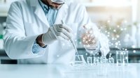 Laboratory scientist in protective wear conducting research with test tubes and glassware, digital network visualization effect showing data analysis.