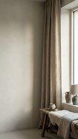 Minimalist bedroom corner with natural linen curtains, wooden bench, and neutral wall decor, suitable for interior design and home styling projects.