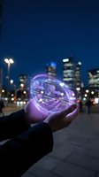 Hand holding glowing purple holographic globe with business icons and network connections against urban night skyline, representing digital transformation, innovation, and global technology solutions.