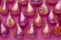 Shimmering teardrop ornaments with glitter and metallic accents arranged on vibrant pink background, perfect for holiday decorations, festive designs, and seasonal marketing materials.