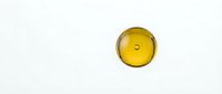 Golden yellow oil drop with smooth surface isolated on white background for skincare and cosmetic product design applications.