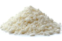 Fresh crumbled feta cheese pile isolated on white background, dairy product with soft grainy texture and traditional Mediterranean flavor for cooking and garnish.