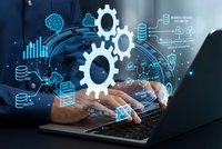 Business professional using laptop with digital gear icons and data analytics overlay representing automation technology and industrial innovation processes.