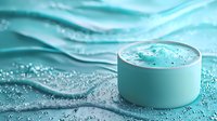 Luxurious aqua-colored moisturizing face cream jar on wavy water surface with splashes and droplets, creating spa-like atmosphere for cosmetic product photography.