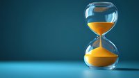 Glass hourglass with flowing golden sand against deep blue background, symbolizing time management and deadline concepts.