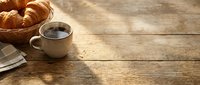 Morning coffee and fresh croissants on rustic wooden table with warm sunlight, cozy breakfast scene for cafe menu design and food photography.