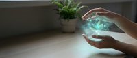 Hands protecting glowing blue cannabis leaf hologram symbolizing medical marijuana care, healthcare innovation, and natural healing therapy concepts.