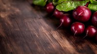 Fresh red radishes with green leaves on dark wooden background, copy space for text. Food photography for healthy eating and farm produce.