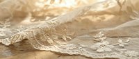 Delicate lace fabric with intricate embroidered details and floral patterns on neutral beige background, suitable for wedding dress design, bridal wear, and textile projects.