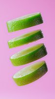 Fresh lime slices floating in sequence on pink background, showing juicy pulp and textured green rind. Creative food photography for cocktail and beverage concepts.