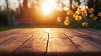 Rustic wooden table surface at sunset with golden bokeh lights and daffodils in background, warm evening atmosphere creates cozy spring garden setting.
