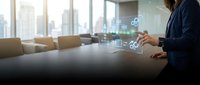Businesswoman in dark blazer interacting with digital holographic interface displaying network icons and data analytics in modern conference room with city skyline view.