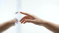 Two hands reaching toward each other with ethereal light and particles between them, symbolizing connection, unity and spiritual bond on white background.