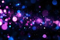 Glowing pink and blue bokeh lights scattered on dark background create magical atmosphere with sparkling particles and blurred circles floating in space.