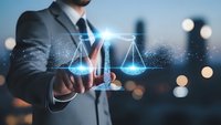Professional businessman touching digital justice scales hologram with glowing particles in modern office environment for legal technology concepts.