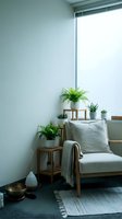Minimalist living room corner with wooden armchair, green plants on tiered stand, natural light from large window creating serene home interior atmosphere.