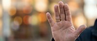Close-up of an open palm with a gold wedding band against a blurred bokeh background, symbolizing commitment and marriage for wedding and relationship concepts.
