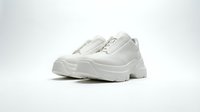 Pair of white chunky platform sneakers with zip closure on a clean white background, showcasing modern streetwear footwear design.