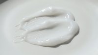 White cosmetic cream or lotion smear on neutral background, suitable for skincare, beauty product packaging, and cosmetics advertising campaigns.
