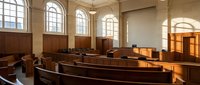 Empty courtroom interior with wooden benches and arched windows. Classic judicial architecture with warm lighting for legal proceedings and justice concepts.