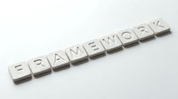 Wooden letter tiles spelling FRAMEWORK arranged in row on white background for business strategy and organizational structure concepts.