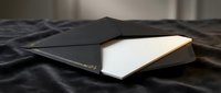 Sleek modern laptop computer with metallic finish closed on dark fabric surface showcasing minimalist technology design for business and productivity concepts.