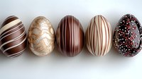 Luxury chocolate Easter eggs decorated with elegant stripes and patterns in white, dark, and milk chocolate with gold shimmer and sprinkles on white background.