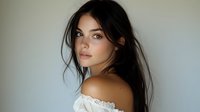 Young woman with long dark hair and olive complexion wearing off-shoulder white lace garment, looking over shoulder with natural makeup for beauty, fashion, and lifestyle content.