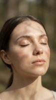 Serene young woman with closed eyes enjoying warm sunlight on face, natural skincare and wellness concept for spa and beauty treatments.