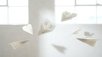 Paper airplanes made from documents flying in bright office space with large windows creating dynamic movement and business communication concept.