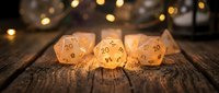 Golden polyhedral dice set glowing on rustic wooden surface with warm bokeh lights creating magical tabletop gaming atmosphere for RPG adventures.