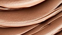 Smooth creamy texture of liquid foundation or concealer makeup product with gentle swirls and waves in nude beige color, close up macro photography.