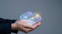 Business professional holding glowing cloud computing hologram with digital icons representing data storage, connectivity and technology solutions.
