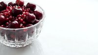 Fresh dark red cherries in a crystal bowl on white surface, ideal for food photography, culinary blogs, recipe websites, and healthy eating content.